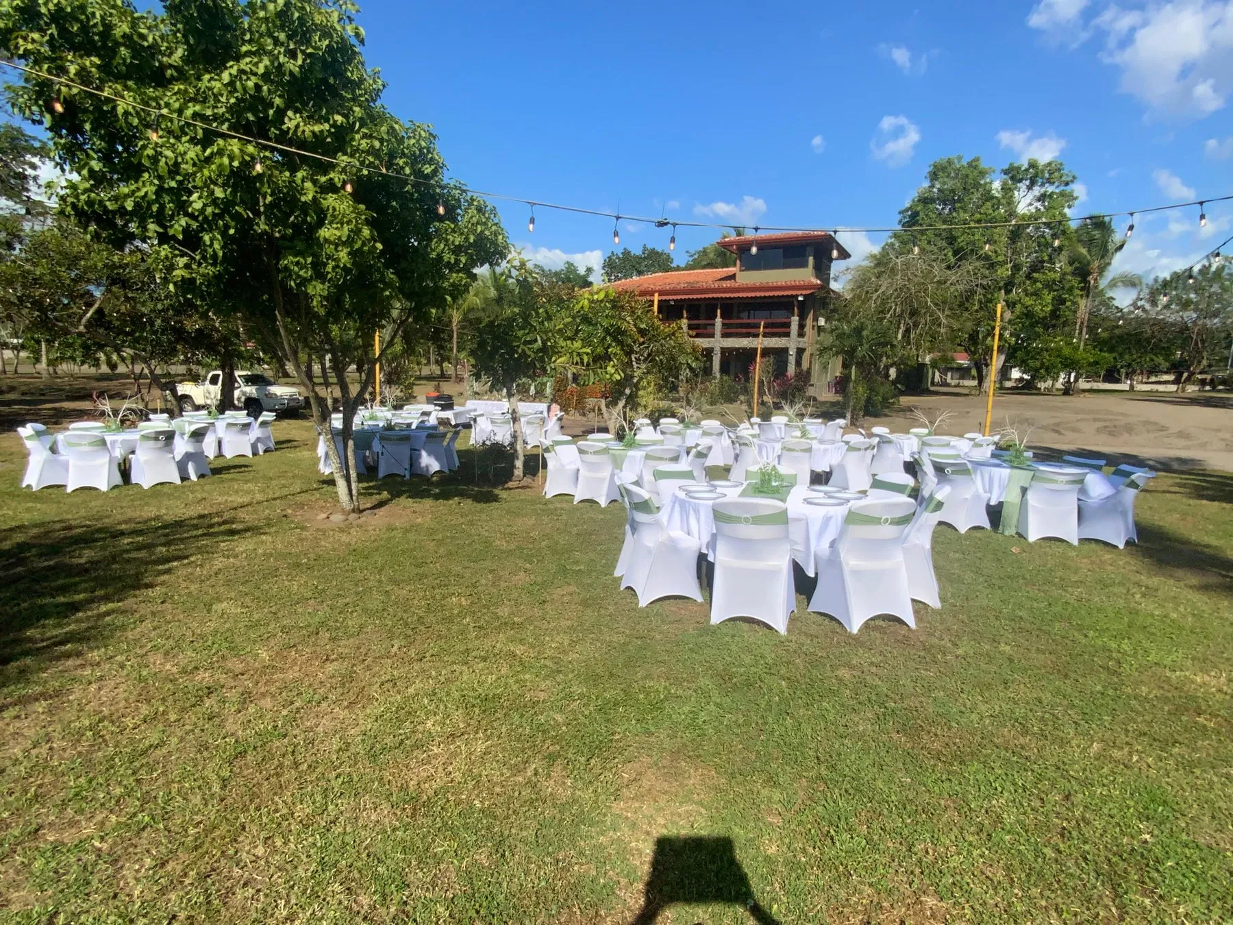 Recepción de boda en un jardín con mesas y sillas blancas