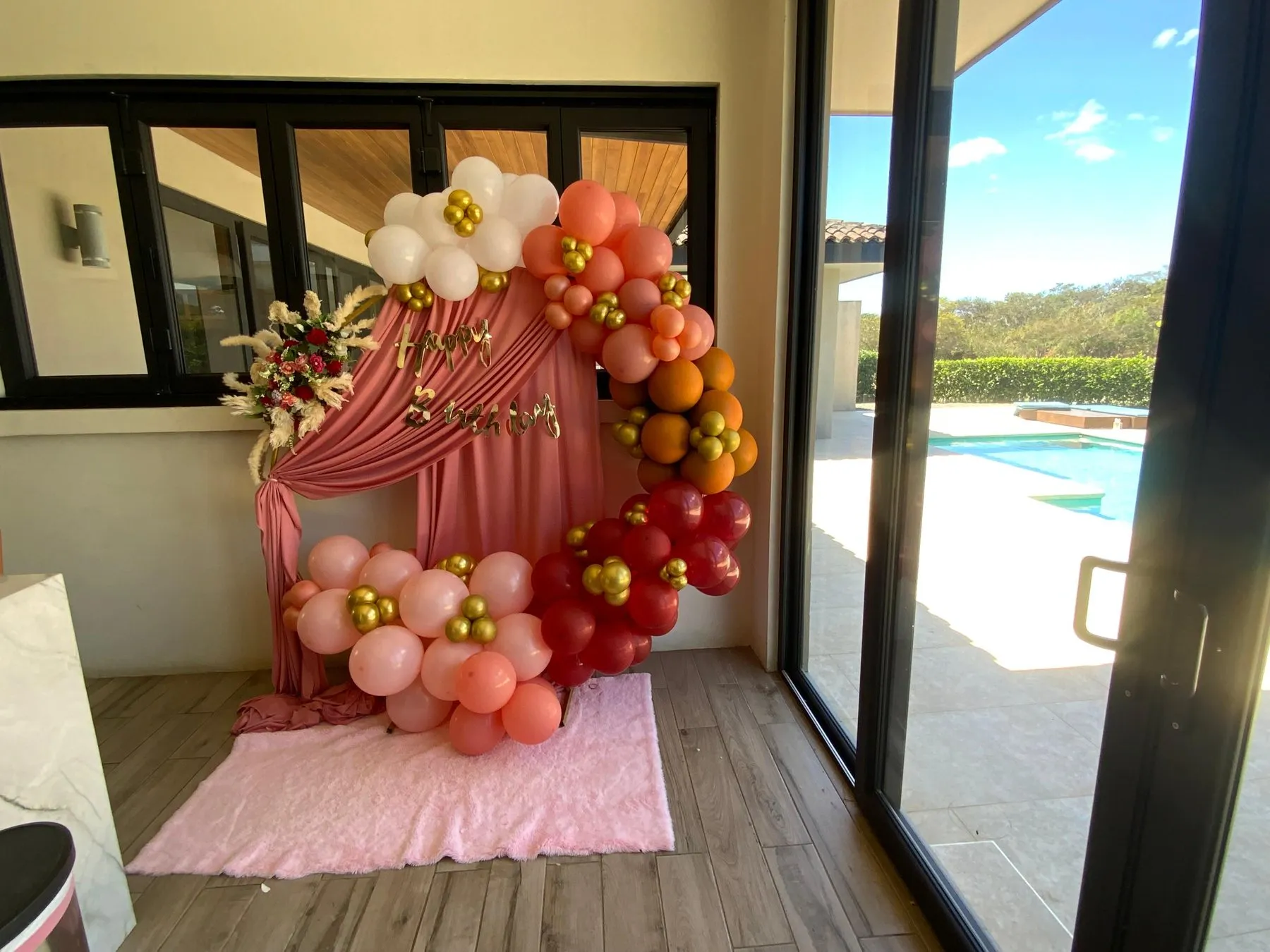 Arco redondo de globos coral y dorados con cortina