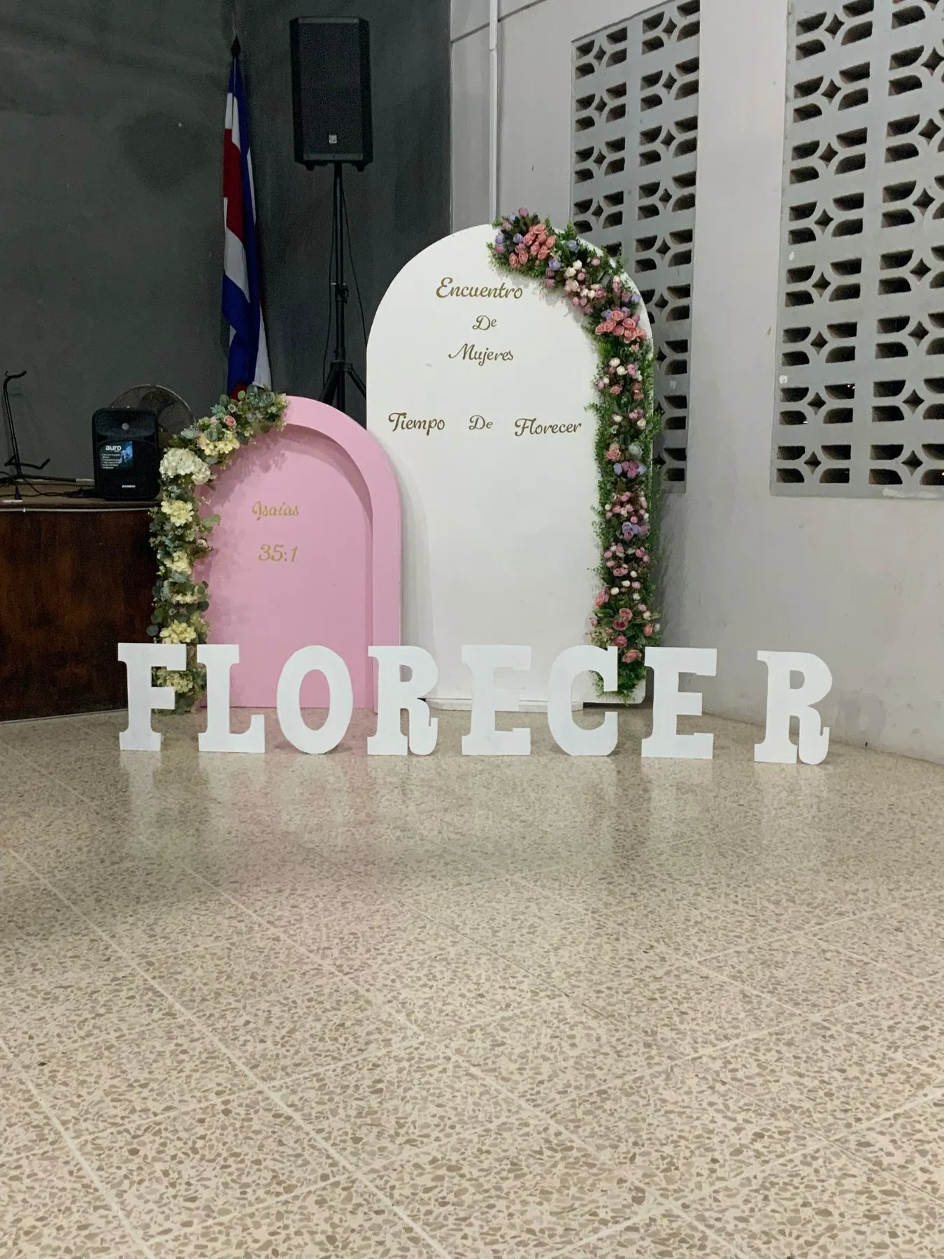 Paneles rosados y blancos con flores y letras que dicen Florecer